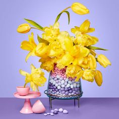 a glass vase filled with yellow flowers and candy