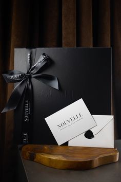 a black box with a white card and a bow on it