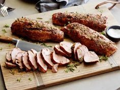 sliced pork on a cutting board next to a knife