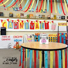 a classroom decorated with colorful streamers and paper cutouts on the wall above a table