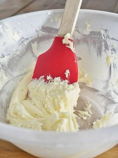 a red spatula in a white bowl filled with batter