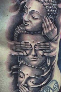 a man with tattoos on his stomach and chest is holding a buddha head in front of him