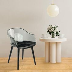 two chairs and a table with flowers on it in a room that has white walls