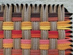 a close up of a woven piece of cloth with multicolored yarn on it