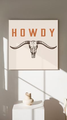 a cow skull is mounted on the wall next to two white vases and a sign that says hodgy