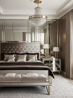 a large bed sitting in a bedroom under a chandelier