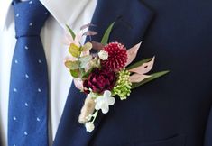 a man wearing a blue suit and tie with flowers on his lapel flower bouquet