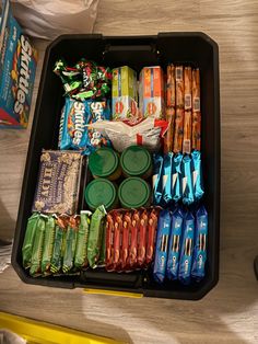 an open lunch box filled with snacks and condiments on top of a table