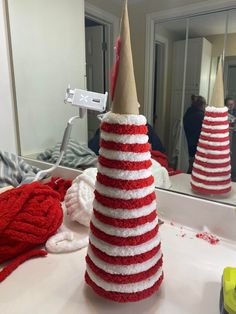 a red, white and blue christmas tree sitting on top of a bathroom counter next to a mirror