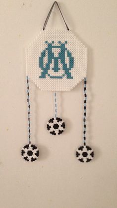 a beaded clock hanging on the wall next to two soccer balls and a pair of scissors