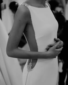 a black and white photo of a woman wearing a dress with beading on it