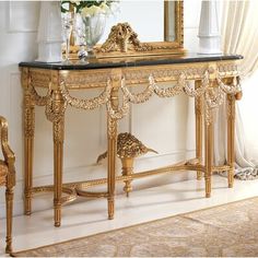 an ornate gold console table with flowers on top