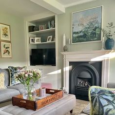 a living room filled with furniture and a fire place in front of a tv mounted on a wall