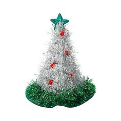 a white christmas tree with red balls on it's top and green grass around the base