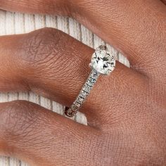 a woman's hand with a diamond ring on top of her finger and an engagement band