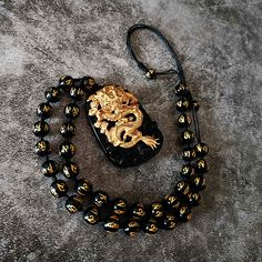 Unleash the Fury of the Dragon! Kings of the spirit world, dragons fear nothing. In Eastern culture, the Yellow Dragon 黃龍 is the fifth element of Earth and the God at the center of the Cosmos This Gold Dragon Necklace features:☯ 18K Carved Gold Dragon ☯ Black Onyx Beaded Necklace ☯ Black Onyx Pendant Are you ready to release the dragon? Luxury Gold Necklaces With Dragon Design, Luxury Yellow Gold Necklace With Dragon Design, Black Jewelry With Dragon Design Collectible, Collectible Black Jewelry With Dragon Design, Adjustable Dragon Design Necklace As A Gift, Adjustable Dragon Design Necklace For Gift, Black Spiritual Jewelry With Dragon Design, Spiritual Black Jewelry With Dragon Design, God At The Center