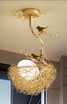 two birds sitting on top of a nest in a window sill hanging from a light fixture