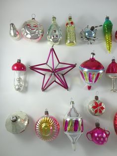 a collection of christmas ornaments are arranged on a white surface, including star ornament and baubles