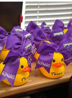 purple and yellow rubber ducks with name tags on them