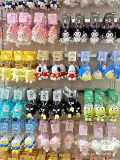 many different kinds of stuffed animals are on display in a toy store with tags attached to them