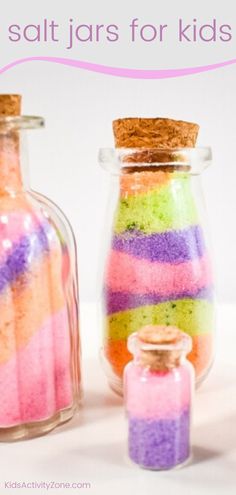 three jars filled with different colored sand next to each other