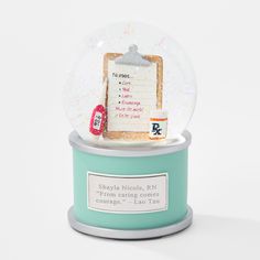 a snow globe sitting on top of a blue stand with a note pad in it