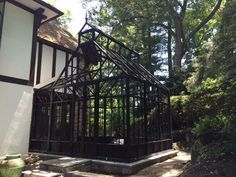 a black and white house in the middle of some trees with stairs leading up to it