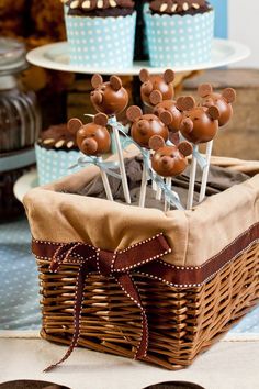 some cupcakes are sitting in a basket with chocolate mouse heads on them,