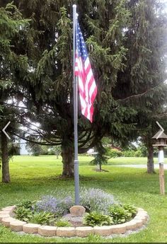 an american flag is in the middle of a flower bed