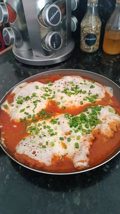 a pan filled with meat and sauce on top of a counter