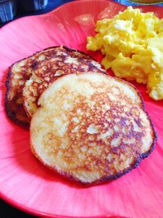 two pancakes and scrambled eggs on a pink plate