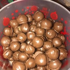 a bowl filled with chocolate covered apples on top of a table