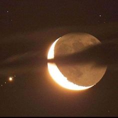 the moon is partially obscured by clouds as it passes through the sky