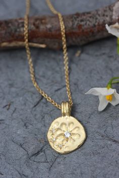 "Beautiful solid 14k, 18 or 22k gold boho necklace for women with a flower pendant set with 4 diamonds. This solid gold necklace has a unique rustic disc as a pendant. The pendant is decorated with an embossed flower and is set with one diamond at the center and 3 smaller ones on the left. The diamonds are set in a unique starburst setting. The pendant has an uneven design, that gives it a distinct handmade and antique style. This necklace is delicate but has a lot of character, and will upgrade Gold Necklace With Diamond Accents In Flower Shape, Gold Necklace With Diamond Accents And Flower Shape, Gold Flower-shaped Necklace With Diamond Accents, Gold Diamond Necklace In Flower Shape For Gift, Gold Diamond Necklace With Flower Shape For Gifts, Flower Shaped Necklace With Single Cut Diamonds For Gift, 22k Gold Flower Pendant Necklace Gift, Gold Flower Pendant With Single Cut Diamonds, 22k Yellow Gold Flower Pendant Necklace