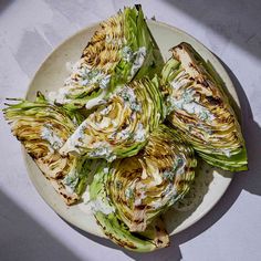 grilled artichokes on a white plate topped with blue cheese and sour cream