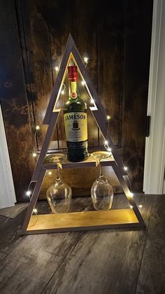 a bottle of jameson is sitting in front of two glasses on a wooden table with lights around it