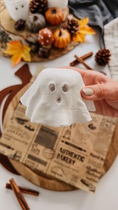 a person holding up a fake ghost on top of a table