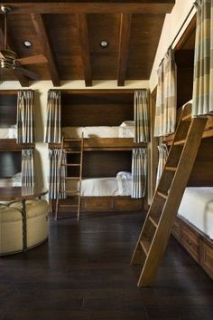 a room with bunk beds and ladders on the ceiling, along with other furniture