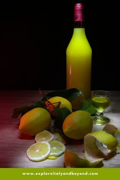 a bottle and some lemons on a table