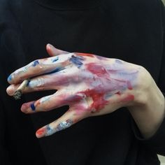 a person with their hands painted red, white and blue while holding something in his left hand