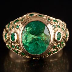 18k Yellow Gold Oval Round Emerald Cluster Cocktail Ring 5.36ctw 10.65gMetal Information: 18k Yellow GoldTotal Weight:10.65gBand Width: 4.3mmSize: 9.5Additional Information: Emerald Shows WearStone InformationMain StoneGem Type: EmeraldShape: Oval (11.5mm x 9.7mm)Color: GreenClarity/Quality: ACarat Weight: 4.48ctNumber of Stones: 1Accent StonesGem Type: EmeraldShape: Round (3.0mm)Color: GreenClarity/Quality: ACarat Weight: .11ctNumber of Stones: 2Accent StonesGem Type: EmeraldShape: Round (2.0mm)Color: GreenClarity/Quality: ACarat Weight: .03ctNumber of Stones: 10Accent StonesGem Type: EmeraldShape: Round (1.75mm)Color: GreenClarity/Quality: ACarat Weight: .02ctNumber of Stones: 10Accent StonesGem Type: EmeraldShape: Round (1.5mm)Color: GreenClarity/Quality: ACarat Weight: .015ctNumber of Luxury Oval Tsavorite Jewelry, Gold Statement Ring, Emerald Ring, Cocktail Rings, Emerald, Statement Rings, Yellow Gold, Yellow, Stone