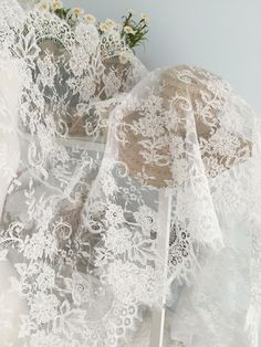 an image of white lace on fabric with flowers