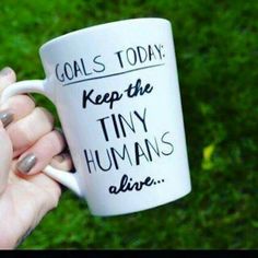 someone holding a coffee mug that says goal's today keep the tiny humans alive