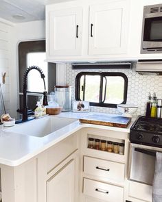 a kitchen area with sink, stove and microwave in the back ground next to cabinets