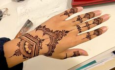 a woman's hand with henna tattoos on it