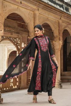 This exquisite Black Chanderi Silk Anarkali Suit Set features intricate Kashmiri embroidery, detailed with sequins and beads, and is lined with cotton voile. Completing the look is a solid chanderi silk slip-on trousers and a chanderi silk embroidered dupatta with scalloped edges. Color: Black Top: Chanderi Silk Bottom: Chanderi Silk Dupatta: Chanderi Silk Top Length: 48" Sleeves Length:17" Bottom Length: 38" Lining: Cotton Voile Occasion: Festive Print-Pattern: Paisley Ornamentation: Thread Wor Phulkari Pants, Embroidery Anarkali, Lucknowi Kurta, Anarkali Designs, Black Anarkali, White Anarkali, Silk Anarkali Suits, Kashmiri Embroidery, Patiala Salwar Suits