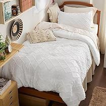 a bed with white comforter and pillows in a bedroom