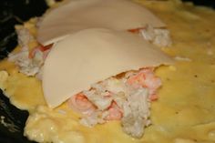 an omelet with shrimp and cheese on it