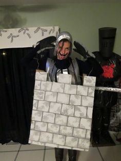 a man dressed up as a knight holding two pieces of white tile in his hands