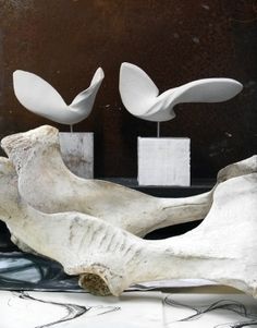 two white sculptures sitting on top of a table